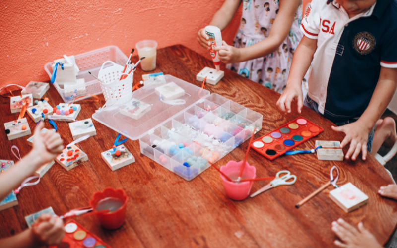 Familie bastelt gemeinsam Weihnachtsgeschenke am Tisch mit verschiedenen Bastelmaterialien