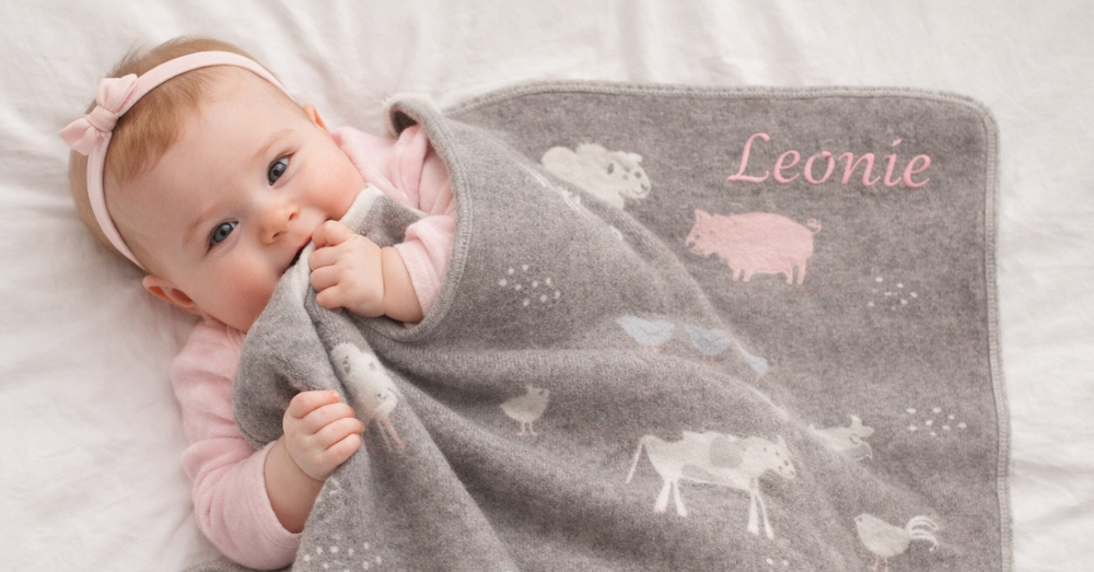 Mädchen kuschelt mit einer personalisierten Babydecke