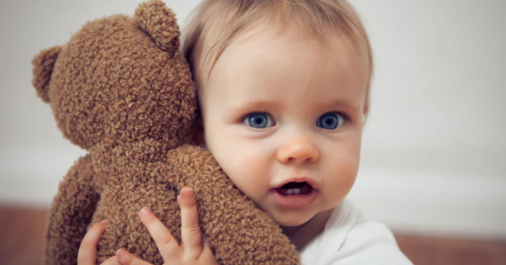 Kind mit personalisiertem Kuscheltier mit Namen als Geschenk